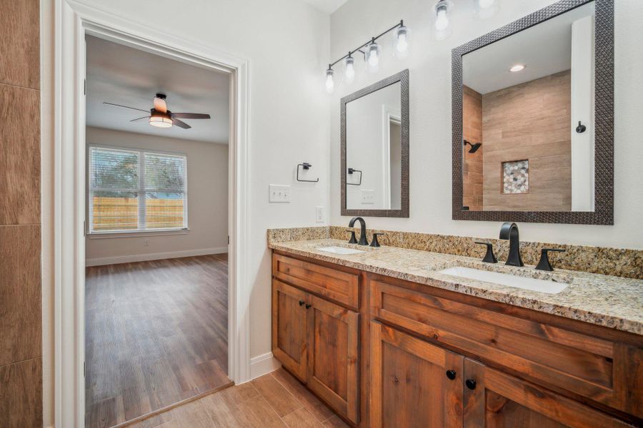 Full bathroom featuring a sink, baseboards, wood finished floors, and a ceiling fan