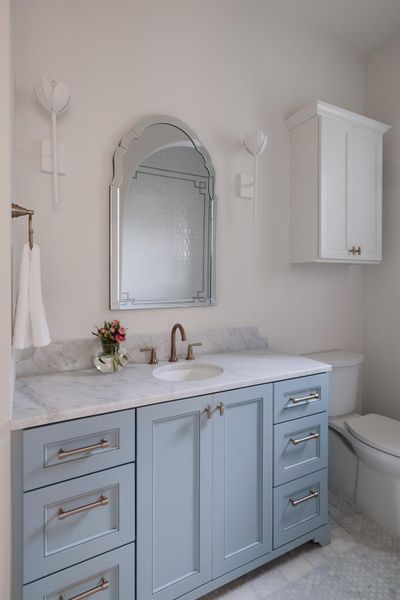 Hall bath with designer cabinets, fixtures, mirror and tile work.