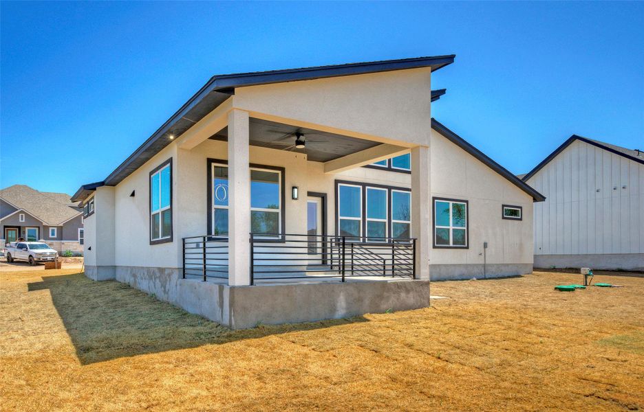 Clean lines and a covered concrete porch define this modern backyard elevation under clear blue skies. Clean lines and a covered concrete porch define this modern backyard elevation under clear blue skies.