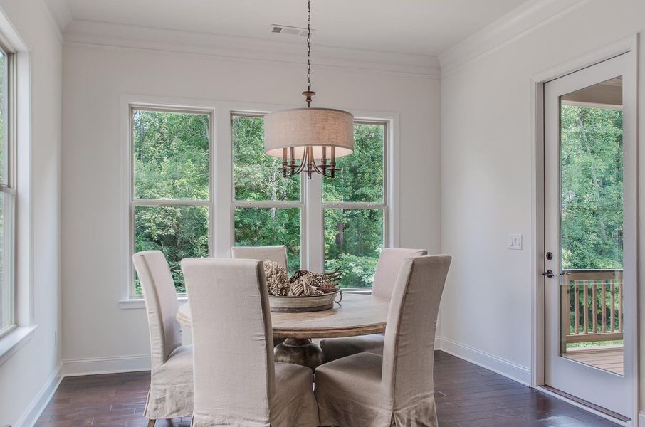 Dining room with crown molding, dark wood finished floors, and a chandelier Dining room with crown molding, dark wood finished floors, and a chandelier