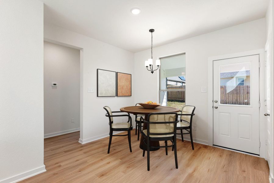 This charming eat-in kitchen offers a bright and inviting spot for casual dining, situated perfectly to enjoy natural light. The space features a large window, glass-paneled back door to access rear patio and yard, and a black pendant light fixture for added lighting. *Virtually Staged This charming eat-in kitchen offers a bright and inviting spot for casual dining, situated perfectly to enjoy natural light. The space features a large window, glass-paneled back door to access rear patio and yard, and a black pendant light fixture for added lighting. *Virtually Staged