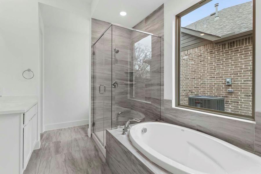 Bathroom with a shower stall, a bath, vanity, and recessed lighting Bathroom with a shower stall, a bath, vanity, and recessed lighting