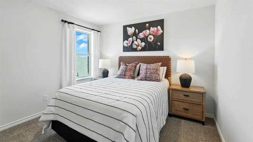 Bedroom with dark colored carpet and baseboards
