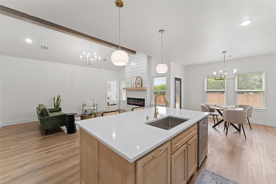 Kitchen with a sink, a chandelier, light wood finished floors, light countertops, and recessed lighting Kitchen with a sink, a chandelier, light wood finished floors, light countertops, and recessed lighting