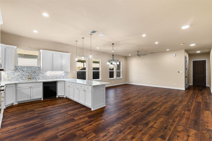 Kitchen with white cabinetry, dark hardwood / wood-style floors, and black dishwasher