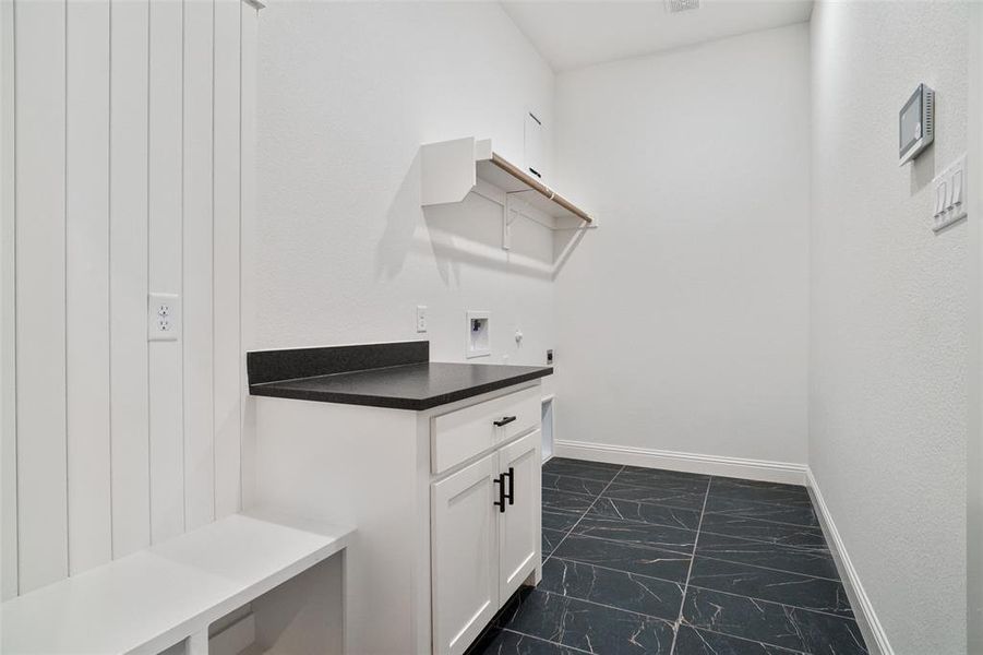 Laundry area with washer hookup, dark marble finish floors, hookup for an electric dryer, and cabinet space