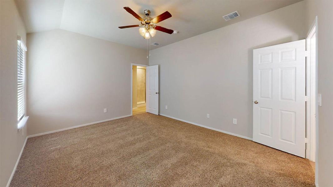 Unfurnished bedroom with vaulted ceiling, carpet, and a ceiling fan