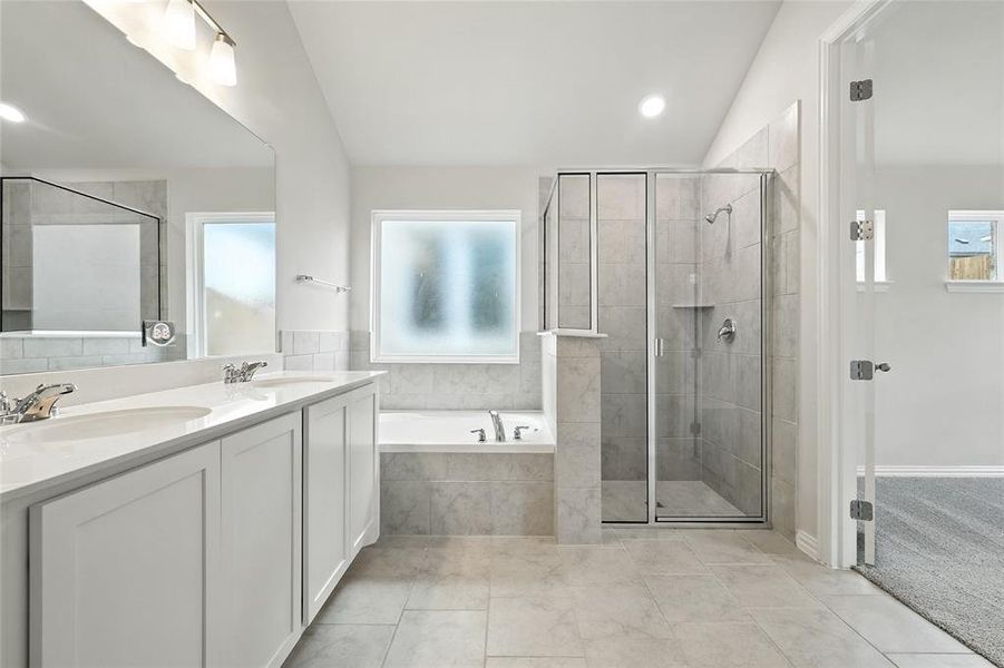 Bathroom featuring a garden tub, a stall shower, double vanity, recessed lighting, and vaulted ceiling Bathroom featuring a garden tub, a stall shower, double vanity, recessed lighting, and vaulted ceiling