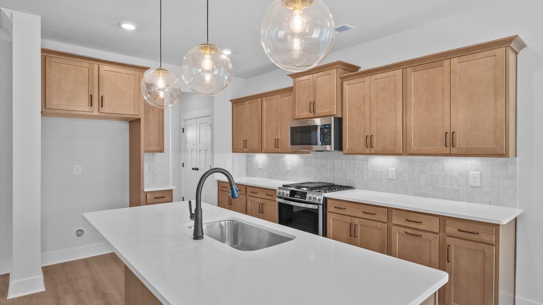 Memorable meals begin in this vibrant kitchen with pendant lighting and a thoughtfully designed island