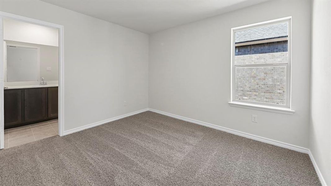 Empty room with light colored carpet and baseboards