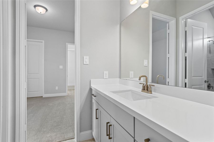 This well-appointed full bath serves two secondary bedrooms and features a convenient private entrance from one. Highlights include a versatile tub/shower combination and an expansive vanity topped with a sleek undermount sink.