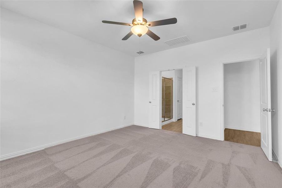 Unfurnished bedroom with ceiling fan and light carpet