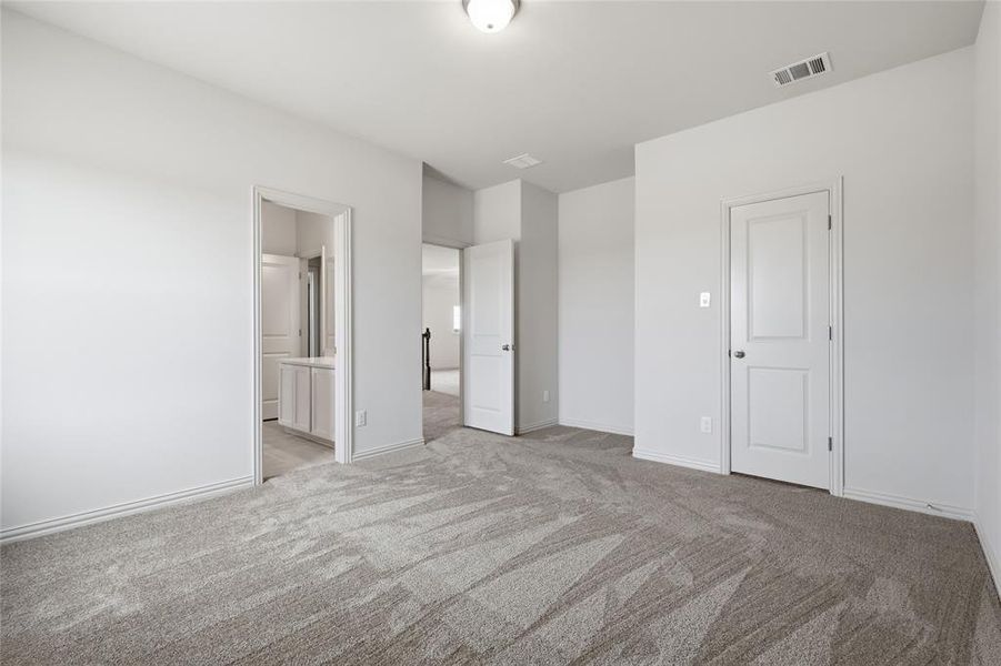 Spacious room with light gray patterned carpet and white walls