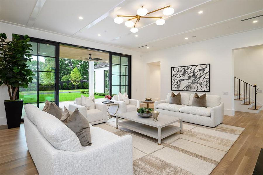 Living room with light wood finished floors, recessed lighting, and a chandelier Living room with light wood finished floors, recessed lighting, and a chandelier