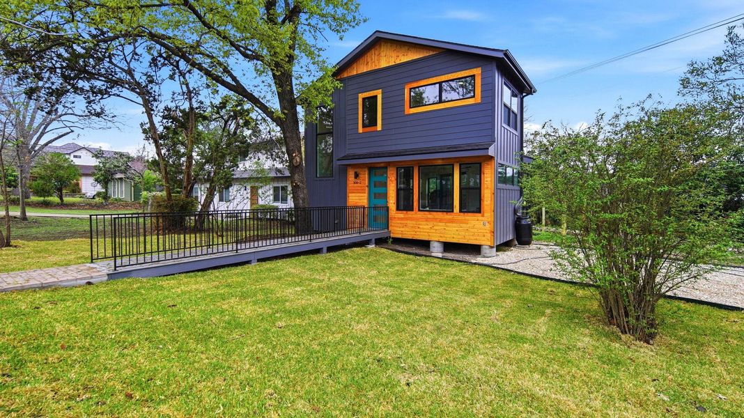 View of front facade featuring a deck and a front lawn