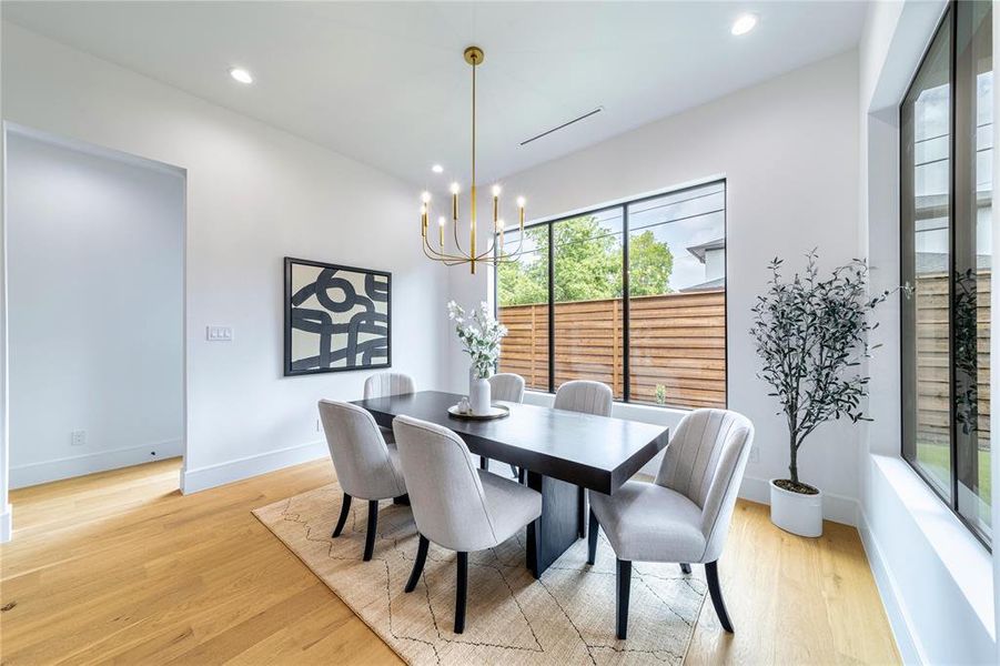Dining room with hanging lights and light wood-type flooring