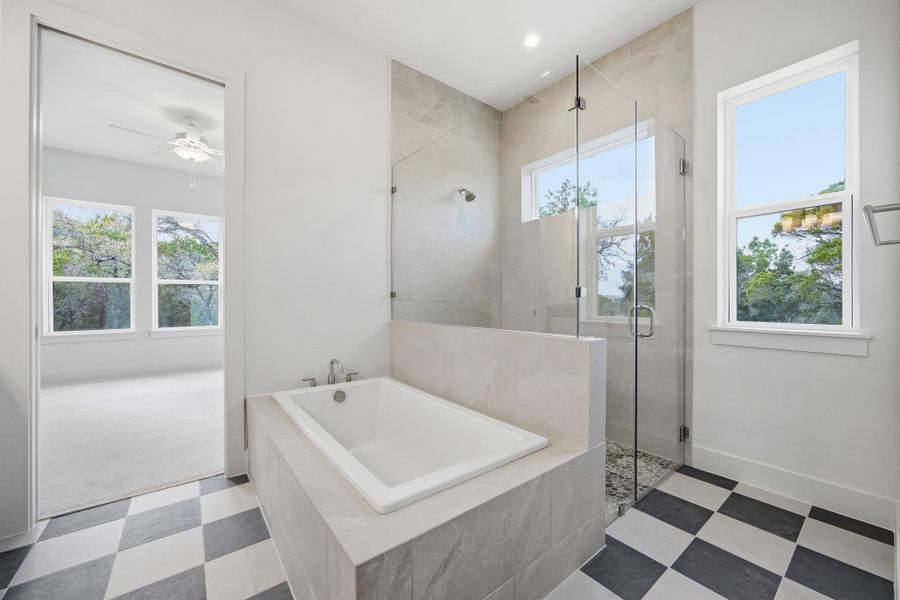 Primary ensuite, soaking tub, and walk in shower zero threshold shower.