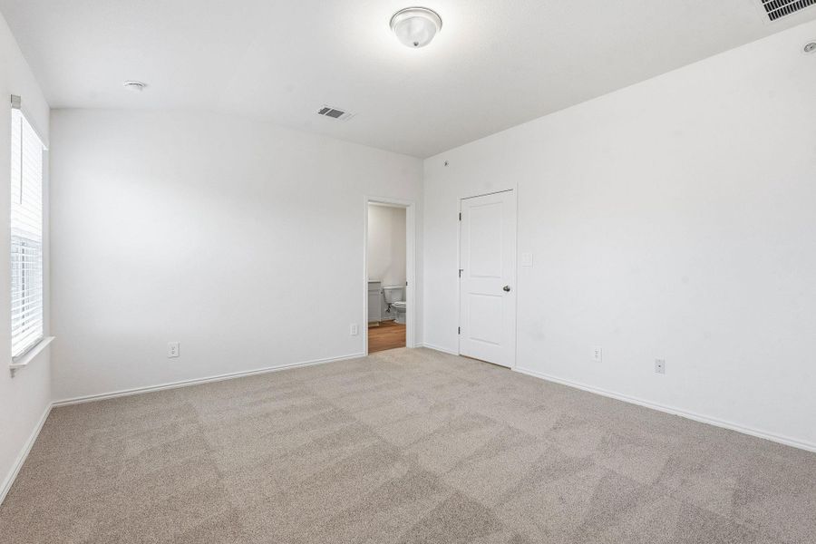 Room featuring neutral-toned carpet, a window with blinds, and white walls