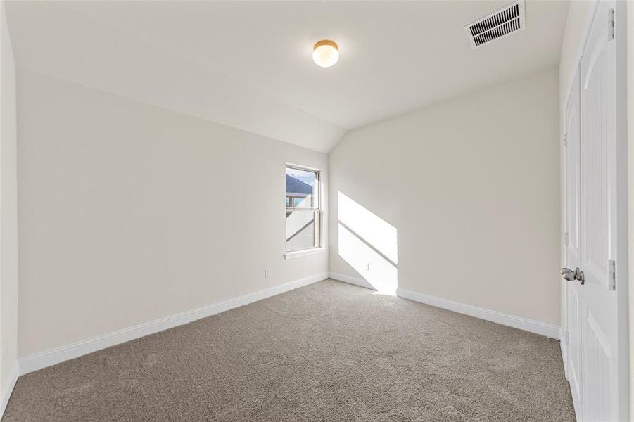 Carpeted spare room with lofted ceiling