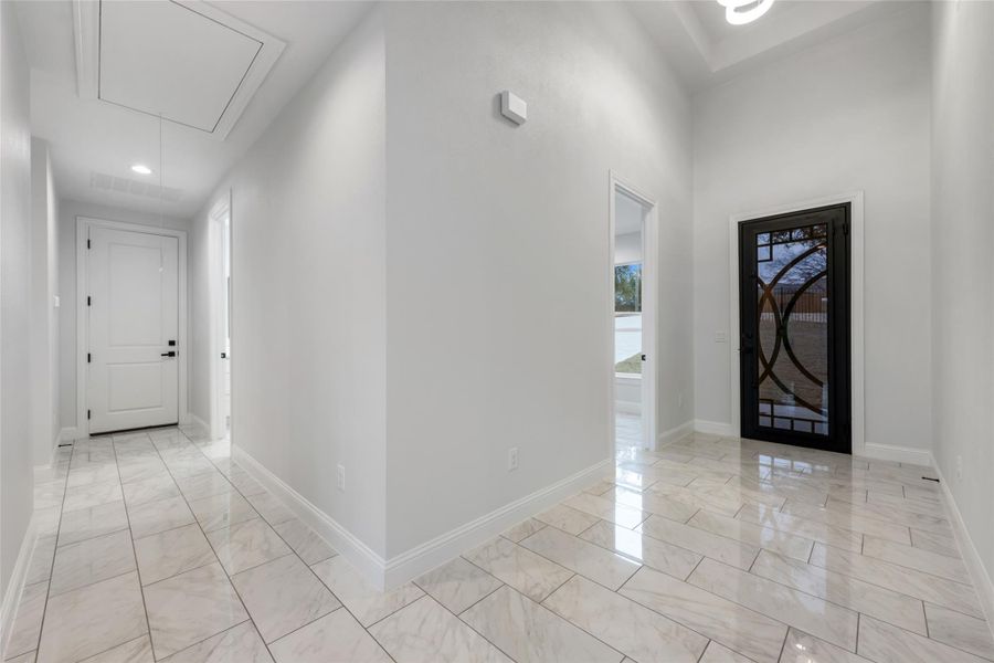 Foyer entrance with light marble finish flooring and recessed lighting