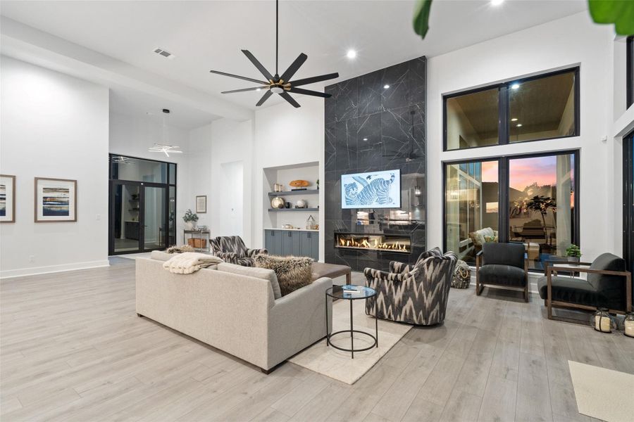 From the moment you enter, soaring ceilings, expansive walls of glass, and designer finishes create an atmosphere of understated elegance. The main level is thoughtfully curated for both grand entertaining and everyday living, featuring a private study, an expansive great room, formal dining area, and a chef-inspired kitchen outfitted with premium luxury appliances, a walk-in pantry, and an oversized center island ideal for gathering.