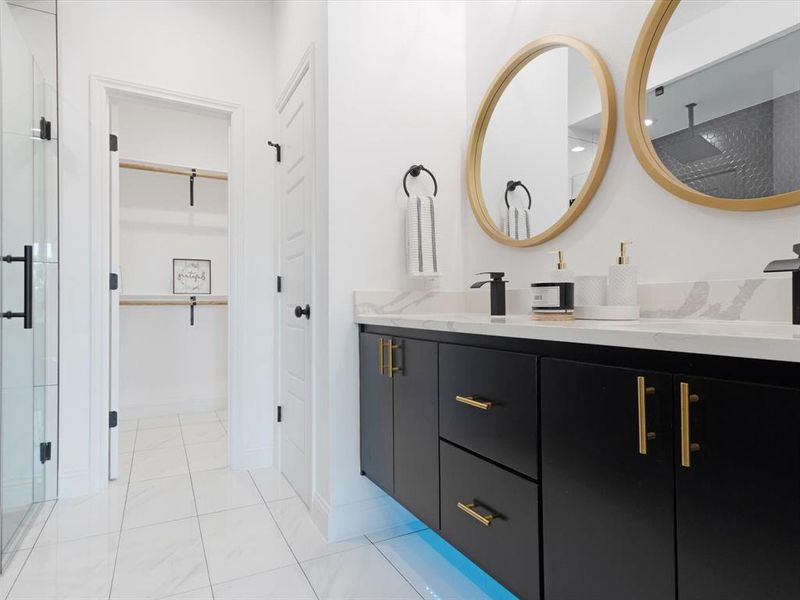 Bathroom with a shower with door, vanity, and tile patterned floors