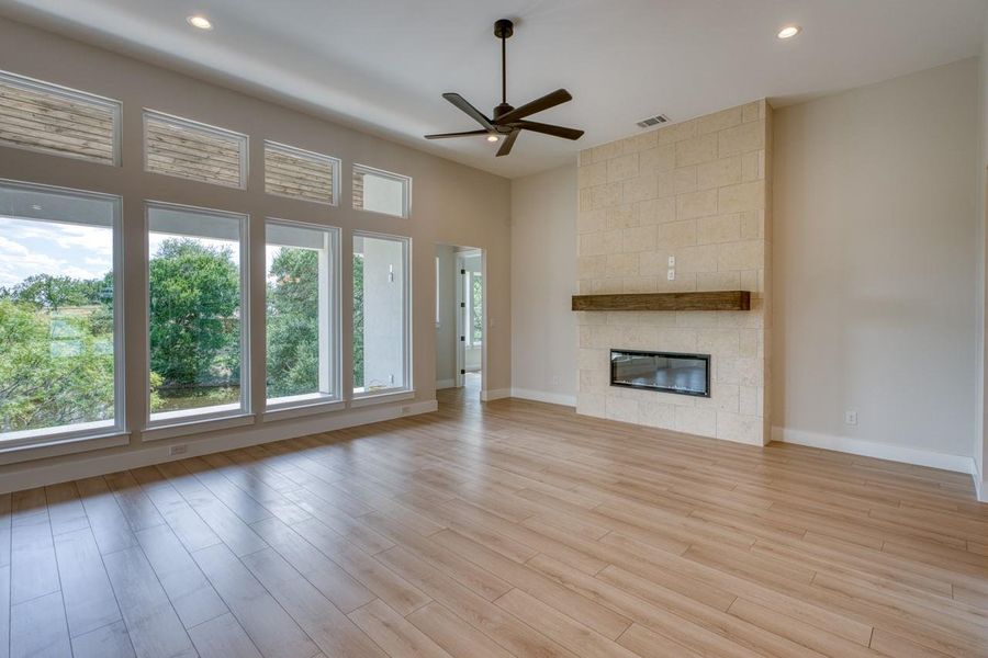 A striking stone fireplace and vast windows define this inviting living space.