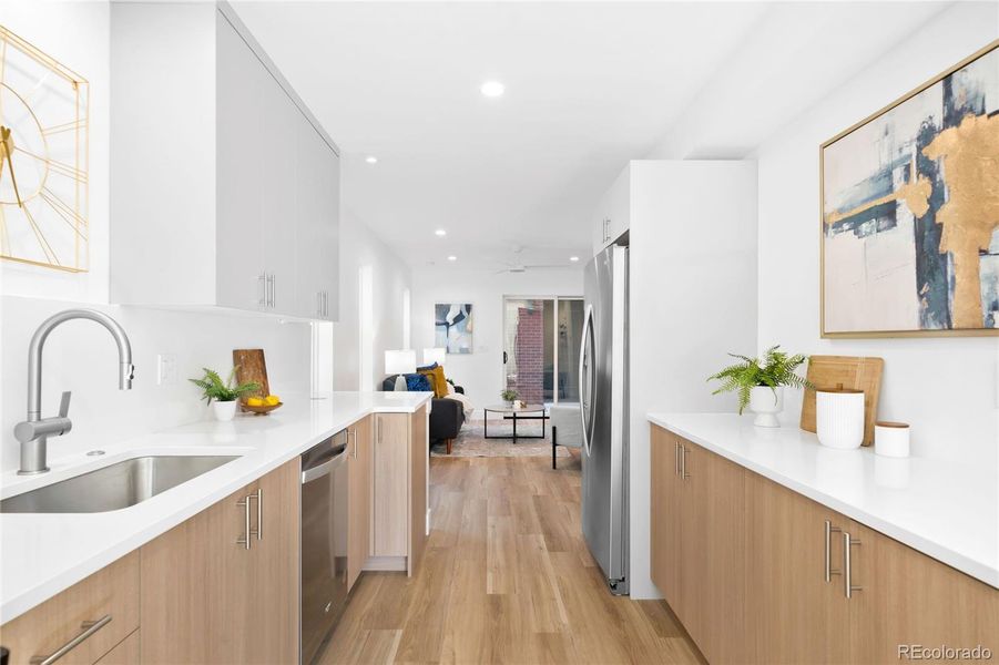Clean lines and warm wood tones define this airy kitchen that opens seamlessly to the living area.