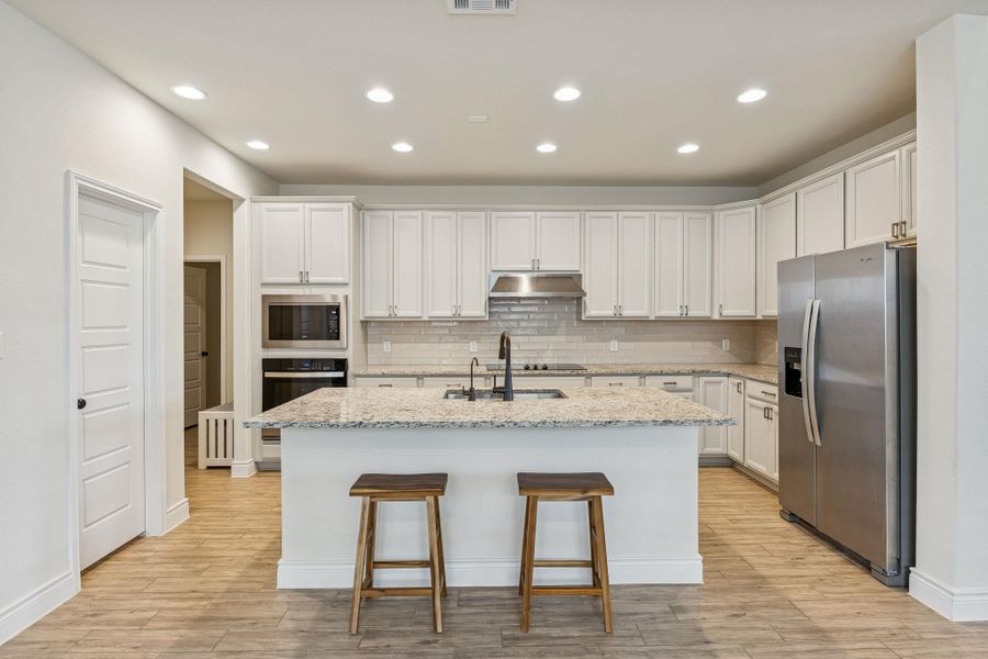 Open kitchen with center island and white cabinets