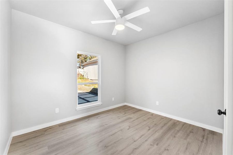 Empty room with wood finished floors and ceiling fan