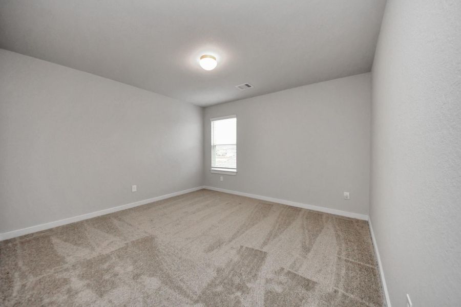 Secondary bedroom features plush carpeting, large windows that let in plenty of naturallight, bright paint, and spacious closets. Sample photo of completed home with similar floor plan. Actual colors and selections may vary. Secondary bedroom features plush carpeting, large windows that let in plenty of naturallight, bright paint, and spacious closets. Sample photo of completed home with similar floor plan. Actual colors and selections may vary.