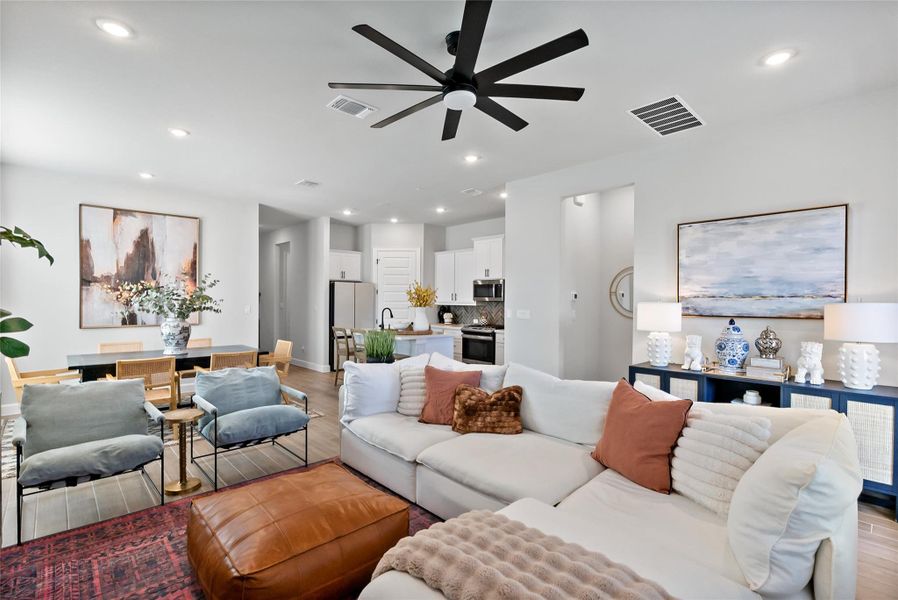 Living room with light wood-style floors, ceiling fan, and recessed lighting