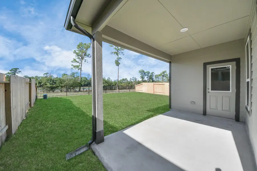Experience outdoor living at its finest on this expansive covered patio, thoughtfully designed for BBQs and delightful outdoor dining. Sample photo of completed home with similar floor plan. Actual colors and selections may vary.