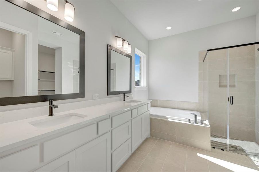 Bathroom with double vanity, a garden tub, a shower stall, light tile patterned flooring, and recessed lighting