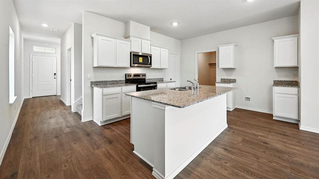 Spacious kitchen featuring white cabinetry, granite countertops, and stainless steel appliances