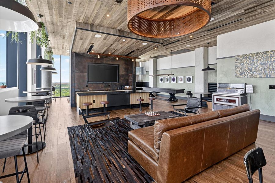 An inviting recreation room with high ceilings, a bar area, and a captivating view.