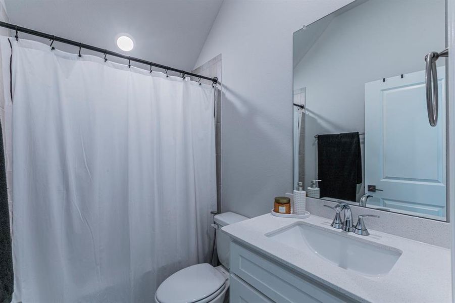 Full bathroom with vanity, vaulted ceiling, and shower / bath combo Full bathroom with vanity, vaulted ceiling, and shower / bath combo