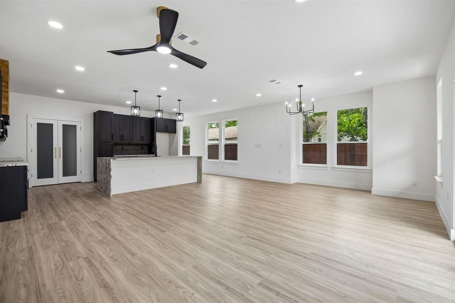 Open-concept interior featuring light wood-finish flooring, recessed lighting, and a contemporary ceiling fan Open-concept interior featuring light wood-finish flooring, recessed lighting, and a contemporary ceiling fan
