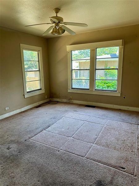 Carpeted spare room with a textured ceiling and ceiling fan Carpeted spare room with a textured ceiling and ceiling fan
