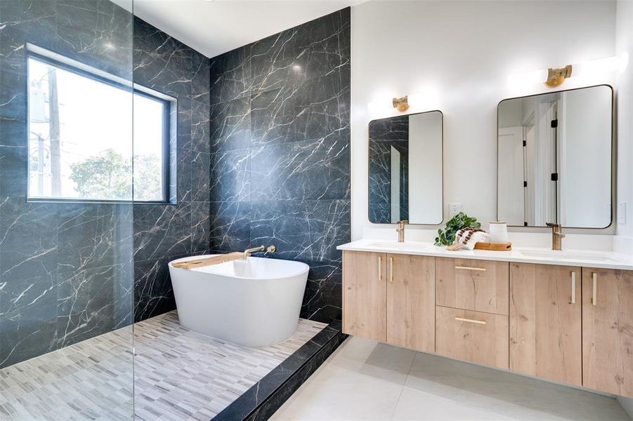 Bathroom featuring vanity, a tub, tile patterned floors, and tile walls