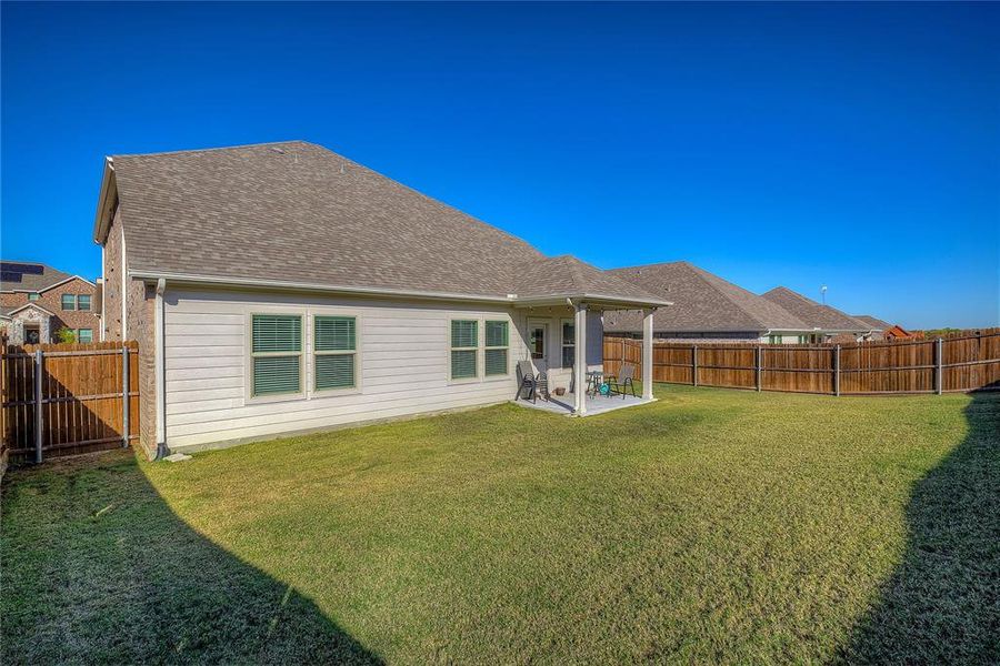 Back of property featuring a yard and a patio