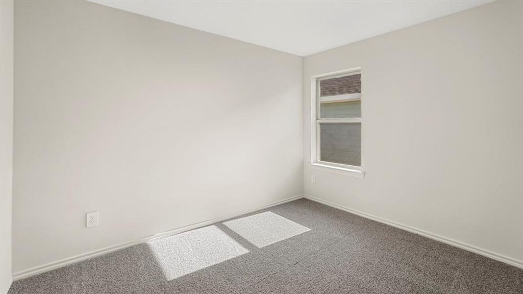 Neutral-toned room featuring a single window and textured carpeting