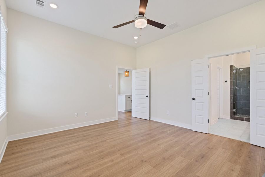 Spacious room featuring wood-finish flooring, high vaulted ceilings, and recessed lighting Spacious room featuring wood-finish flooring, high vaulted ceilings, and recessed lighting