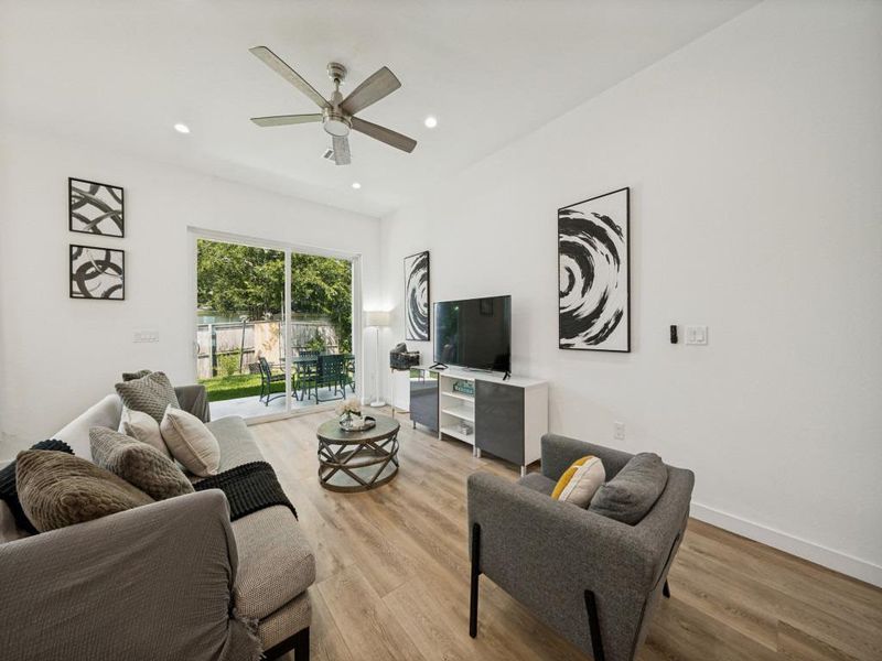 A well-lit living area offers backyard access through sliding glass doors, creating an inviting indoor-outdoor flow. A well-lit living area offers backyard access through sliding glass doors, creating an inviting indoor-outdoor flow.