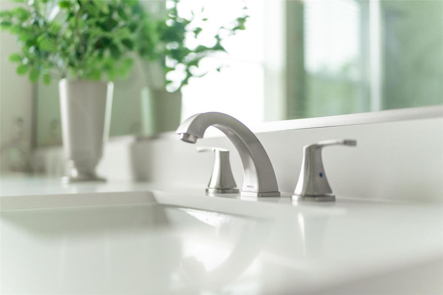 Elegant primary bath in a model home, featuring sleek fixtures and modern design. Elegant primary bath in a model home, featuring sleek fixtures and modern design.