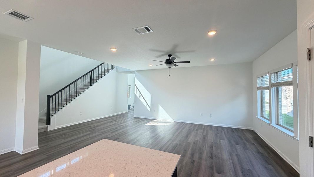 A generously sized living area boasts sleek laminate flooring and a sophisticated modern staircase. A generously sized living area boasts sleek laminate flooring and a sophisticated modern staircase.