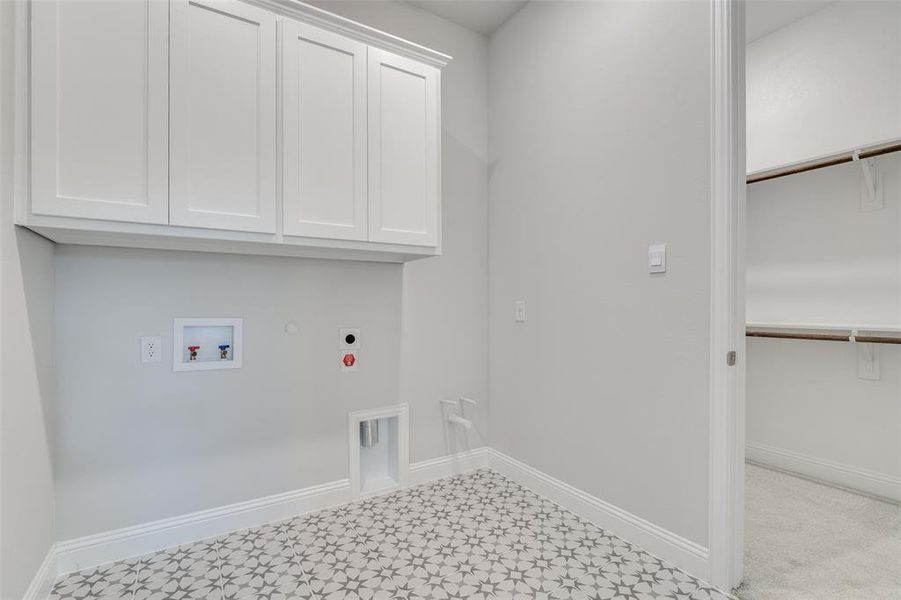 Laundry area featuring gas dryer hookup, hookup for a washing machine, cabinets, and hookup for an electric dryer