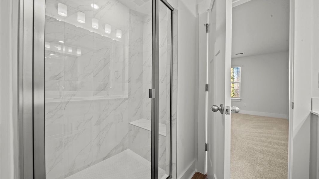 Superior en-suite primary bathroom with stylish dual vanity and tiled walk-in shower crafted with high standards in mind