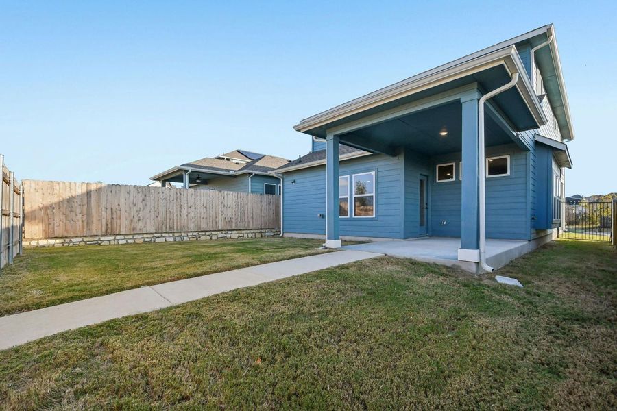 Back of house with a fenced backyard and a patio