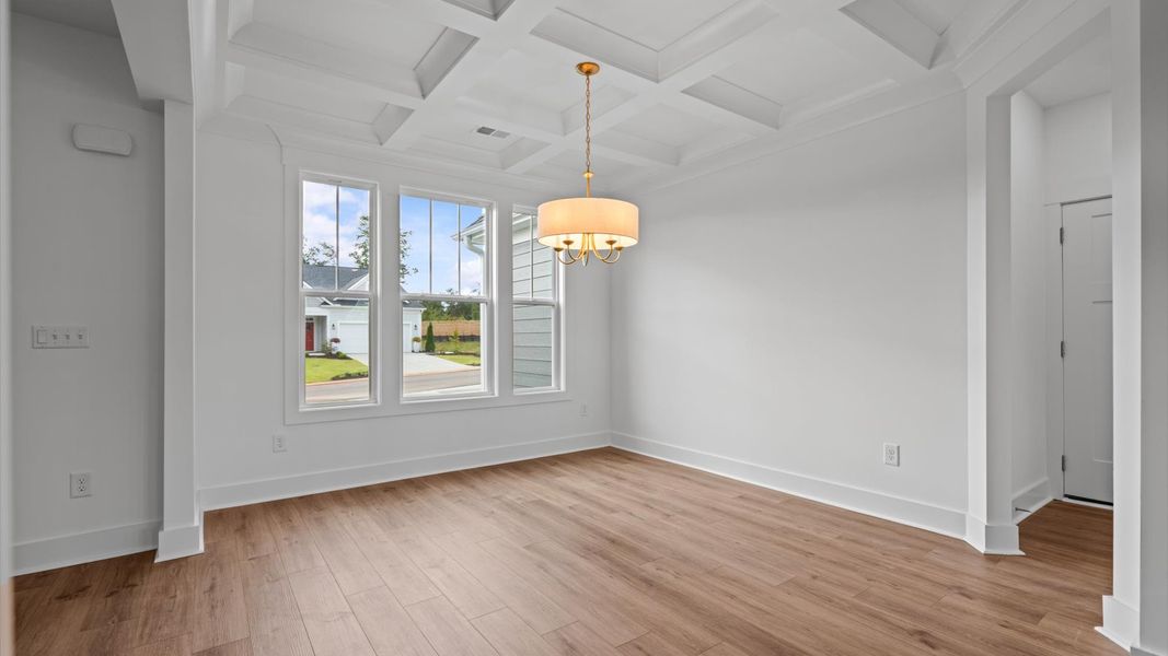 Eye-catching coffered ceiling adds charm to the formal dining space in this superior DRB Homes design